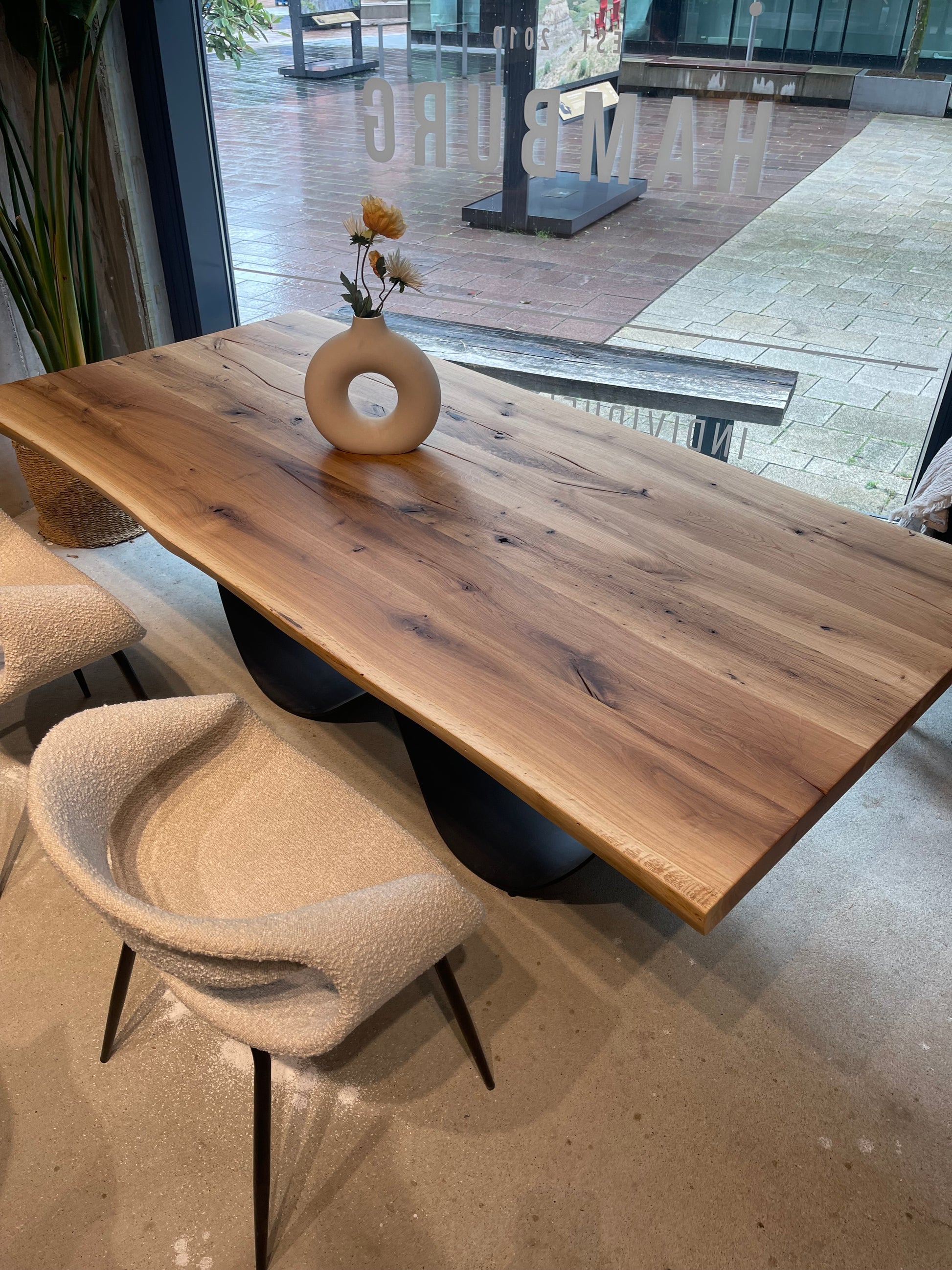 Massivholz-Esstisch aus Wildeiche mit schwarzem Metallgestell in Wellenform