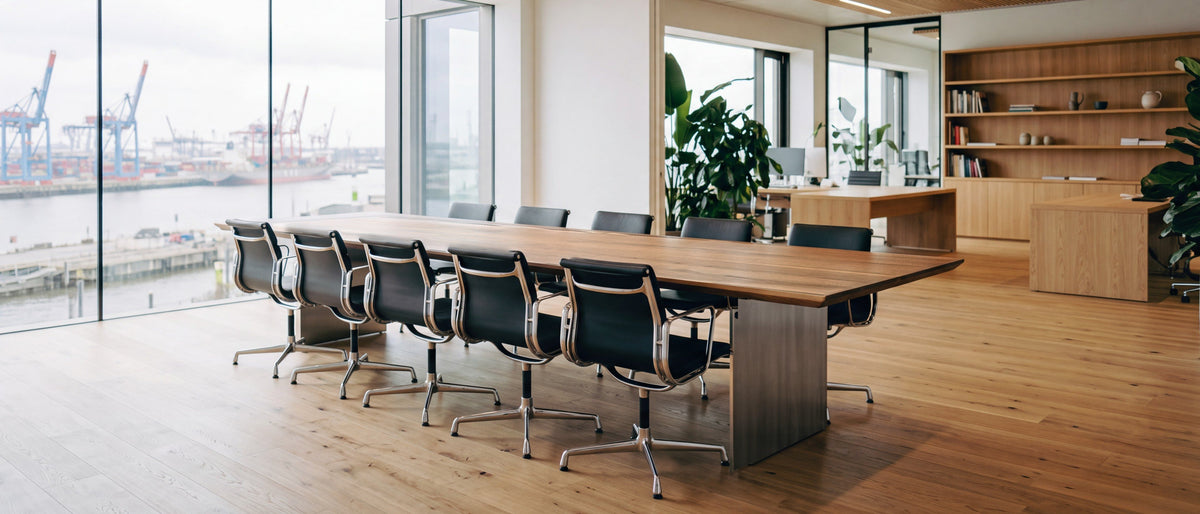 Konferenztisch aus Nussbaum mit Edelstahl-Wangen in einem Büro mit Hafenblick, Visualisierung | Holzwerk Hamburg