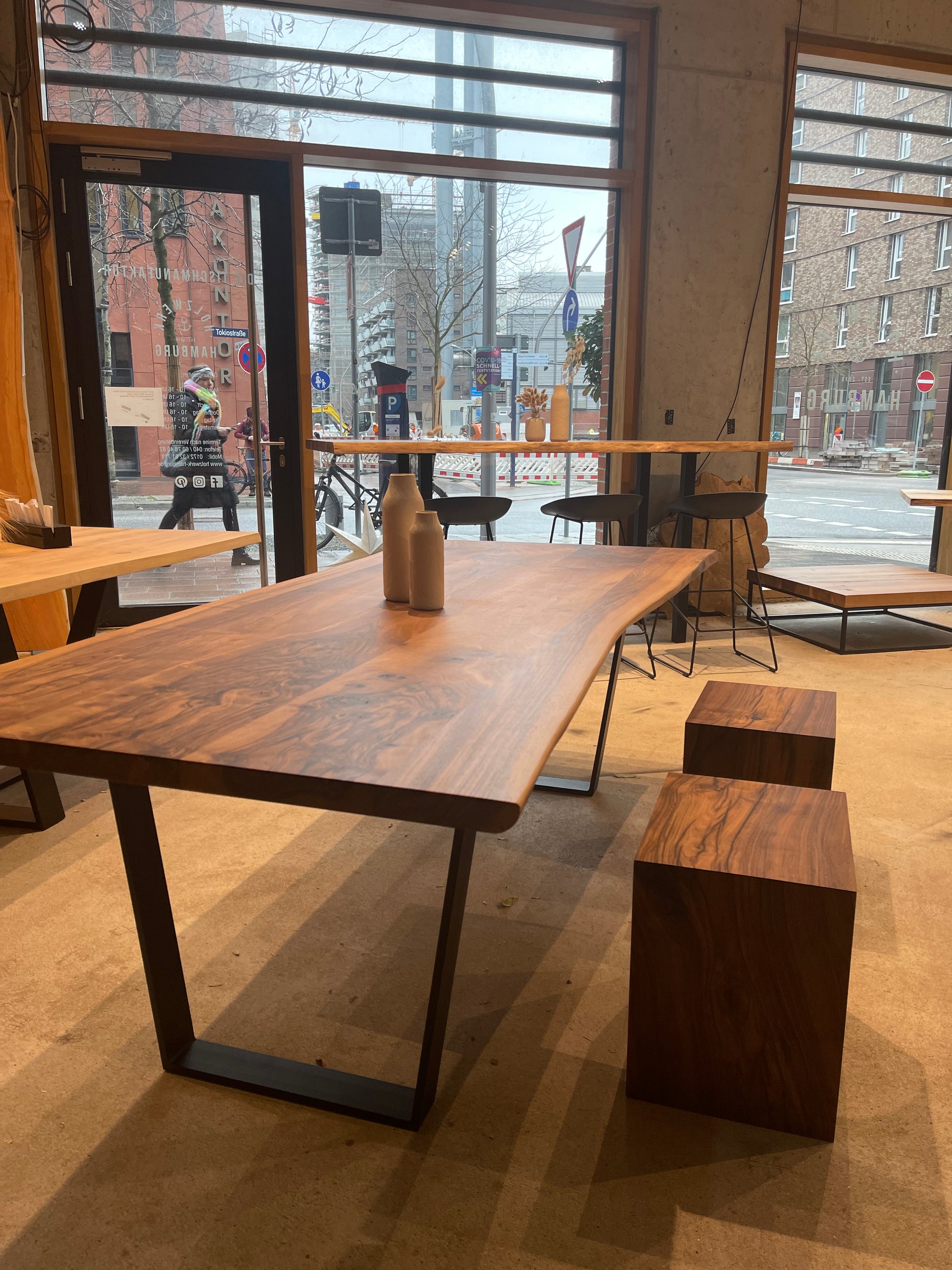 Warmer Esstisch aus Nussbaum mit Stahlgestell in Schwarz | Holzwerk Hamburg