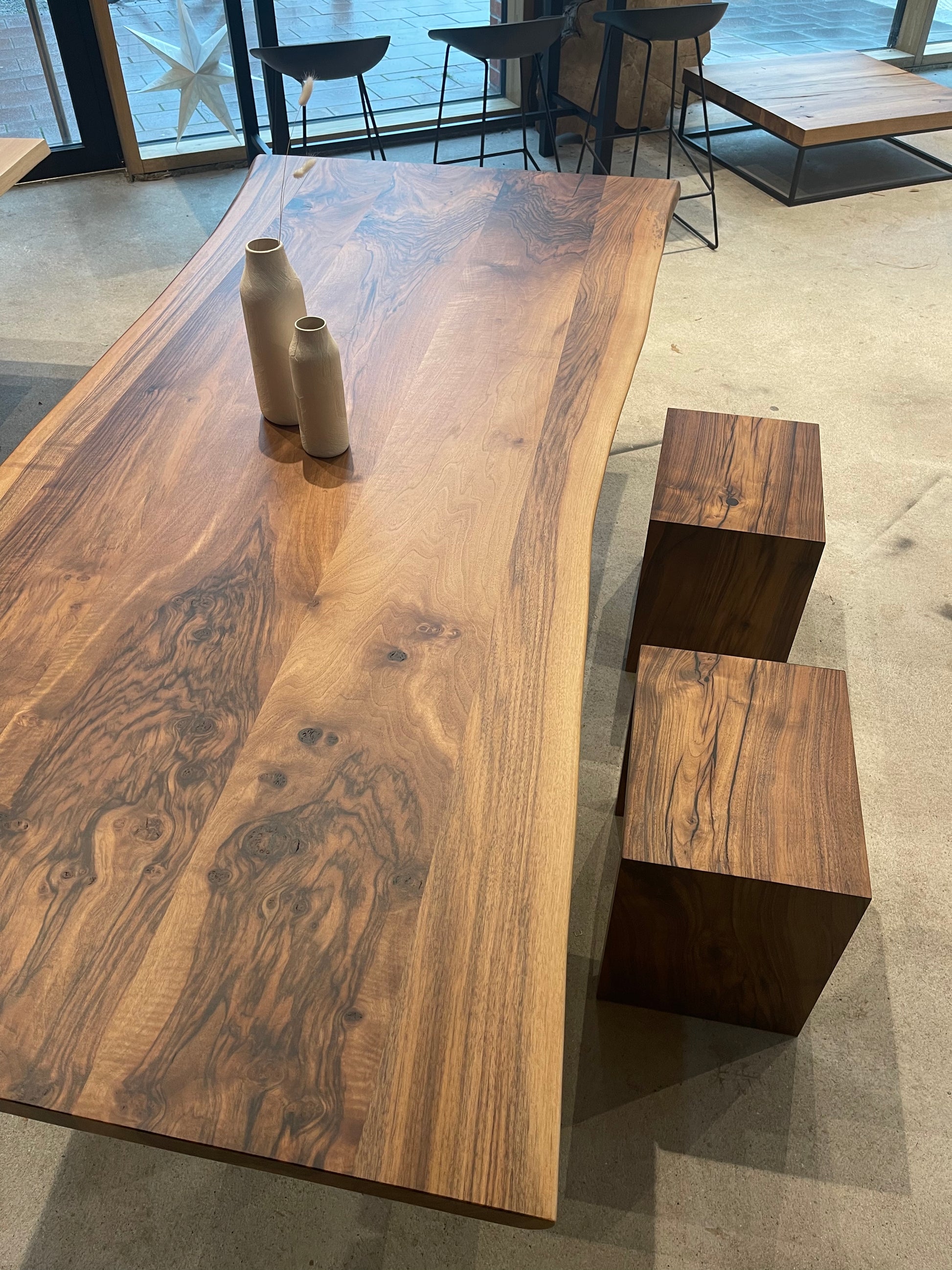 Warmer Esstisch aus Nussbaum mit Stahlgestell in Schwarz | Holzwerk Hamburg